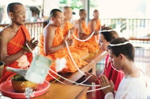 Segen von den Mönchen in Thailand Eine Hochzeitszeremonie in einem buddhistischen Tempel in Thailand ist in erster Linie die Vereinigung Ihrer Herzen! Familie ist im Buddhismus, wenn man immer alles gleichmäßig teilt, egal ob Freude oder Leid! In Thailand können Sie eine buddhistische Hochzeit abhalten, unabhängig davon, welcher Religion Sie angehören, denn im Wesentlichen ist der Buddhismus keine Religion, sondern, wie die Mönche selbst sagen, eine Lebensweise! Eine Hochzeit nach thailändischer Tradition kann auf der Insel Samui, Koh Mak, Koh Chang oder in der Provinz Krabi stattfinden. Das traditionelle buddhistische Hochzeitsritual dauert etwa eine halbe Stunde und bietet Ihnen unbeschreibliche Eindrücke und Emotionen, die Sie bei einer Hochzeit in einem buddhistischen Tempel erleben werden! Die Zeremonie in einem buddhistischen Tempel kann morgens oder nachmittags stattfinden, je nachdem, welche Richtung des Buddhismus in diesem Tempel praktiziert wird. Die Zeremonie beginnt traditionell mit dem Anzünden von Kerzen in der Nähe der Buddhastatue, dem Anzünden von Weihrauch und dem Überreichen von Blumen an Buddha. Der Hochzeitsvorgang in einem buddhistischen Tempel in Thailand besteht aus dem Singen von Mantras. Traditionell wird die Zeremonie von 3 bis 9 Mönchen durchgeführt, da eine ungerade Zahl den Thailändern zufolge Glück bringt. Den Frischvermählten wird eine spezielle Schleife um den Kopf gelegt, deren Enden durch die Hände aller Mönche gezogen werden, wodurch ein ununterbrochener Kreis entsteht und zwei Menschen zu einer Familie verbunden werden. Am Ende der Zeremonie richtet der Abt oder der älteste Mönch ein Abschiedswort an die jungen Leute, die wiederum jedem der Mönche, die die Zeremonie im Tempel durchgeführt haben, Geschenke – wichtige Dinge – überreichen und eine Spende an den Tempel leisten. Nach der Zeremonie ist es Tradition, die Fische im Teich in der Nähe des Tempels zu füttern und einen Spaziergang für malerische Fotos zu machen!