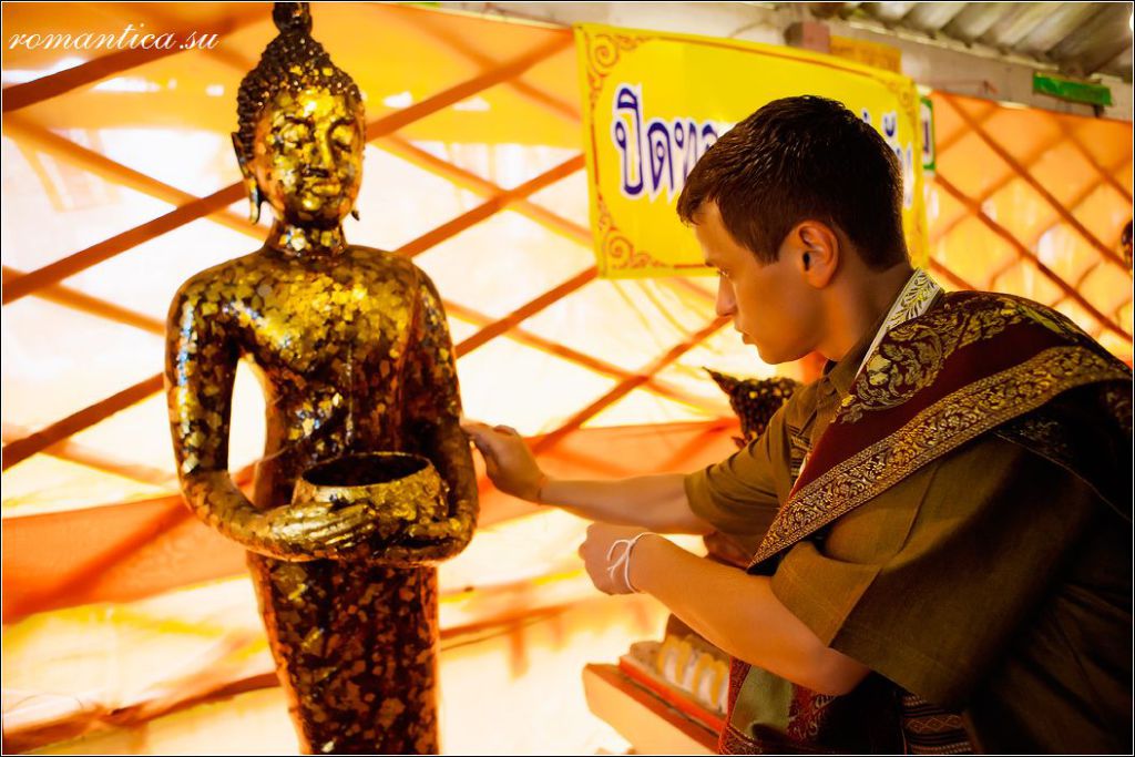 A groom pays respect to Buddhist saints during a wedding ceremony at a Buddhist temple